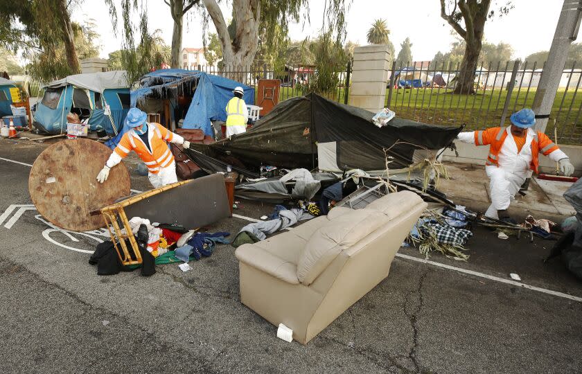 LOS ANGELES, CA - NOVEMBER 01: Members of the clean-up crew dismantled tents located on the Veterans Row homeless encampment along San Vicente Blvd just outside the West Los Angeles Veterans Affairs campus on Monday morning. A variety of organizations with the support of LA County Sheriff officers helped homeless veterans pack up to leave their encampment and move onto the West Los Angeles Veterans Affairs campus located behind a fence of their San Vicente Blvd camp on Monday morning. The encampment, adjacent to the historic VA campus has become a focal point for homelessness in the city, with mayoral candidates making visits over the last year. Veteran Affairs Secretary Denis McDonough, who visited the encampment in October, said that the roughly 40 veterans from Veterans Row would be housed by November. VA campus San Vicente Blvd on Monday, Nov. 1, 2021 in Los Angeles, CA. (Al Seib / Los Angeles Times).