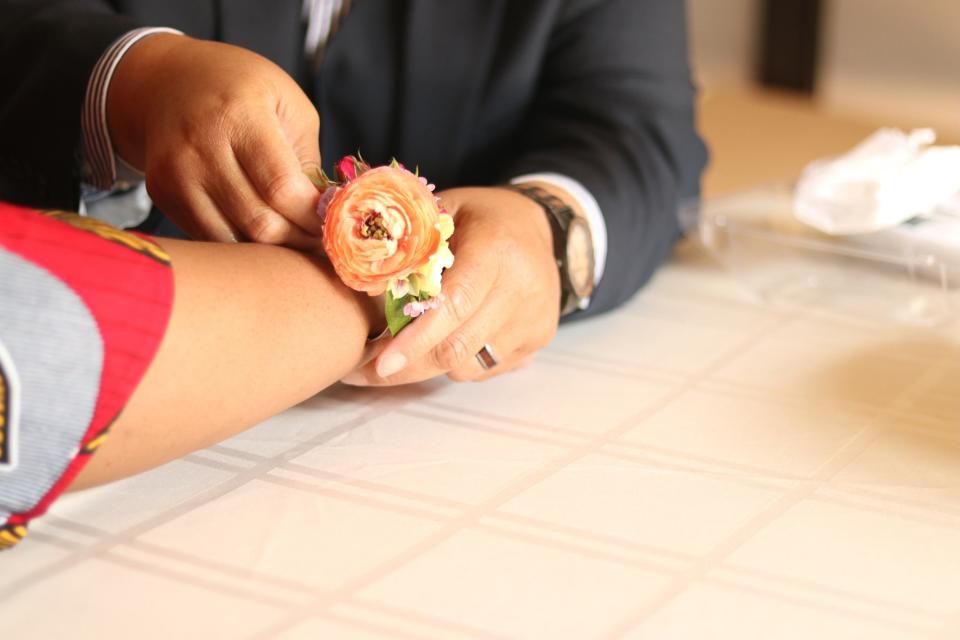 Trinette Johnson-Williams places a corsage on the wrist of her wife, Adriane, as the couple prepared for their evening at OUTMemphis' Queer Prom. Adriane had never been to prom before.