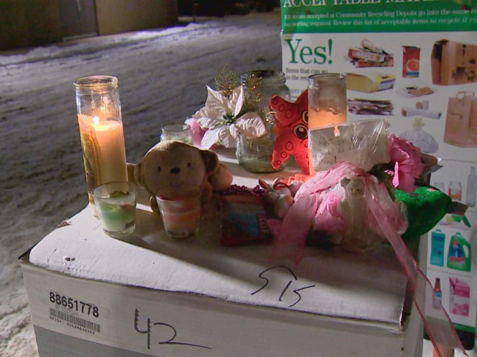 Candles, stuffed animals and other tokens were left in memory of a baby girl found dead in Bowness on Dec. 24, 2017. (Dennis Genereux/CBC - image credit)
