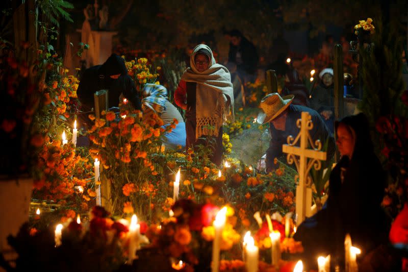 FILE PHOTO: Indigenous people are seen by the graves of their relatives during an annual Day of the Dead celebration, in Santa Maria Atzompa