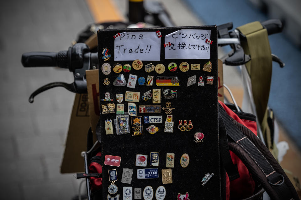 <p>TOKYO, JAPAN - JULY 29: An Olympic pin collector displays his pins as he waits to exchange with other collectors near the Olympic Stadium on July 29, 2021 in Tokyo, Japan. Tokyo metropolitan government reported 3,865 new coronavirus cases today, setting an all-time high for the third day in a row and causing concern amongst officials in Tokyo. (Photo by Carl Court/Getty Images)</p> 