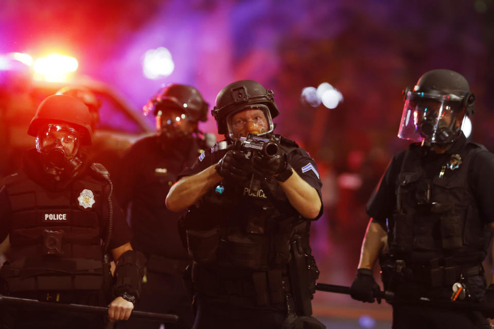 Denver police officers fire canisters to disperse a protest outside the State Capitol over the Monday death of George Floyd, a handcuffed black man in police custody in Minneapolis, Thursday, May 28, 2020, in Denver. (AP Photo/David Zalubowski)