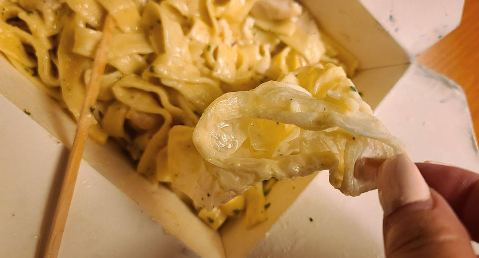 Laurie Graham picks up a plastic glove that was mixed into her pasta from The Cheesecake Factory in Santa Monica.