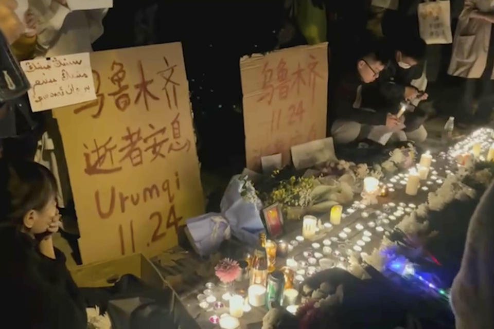 Residents light candles near a sign which reads "Urumqi, 11.24, Rest in Peace" in red — referring to the deadly apartment fire in China's western city of Urumqi that sparked anger over perceptions the country's strict COVID-19 measures played a role in the disaster during a vigil in Shanghai during the early hours of Nov 27, 2022 . What started as an unplanned vigil last weekend in Shanghai by fewer than a dozen people grew hours later into a rowdy crowd of hundreds. The protesters expressed anger over China's harsh COVID-19 policies that they believed played a role in a deadly fire on Nov. 24 in a city in the far west. (AP Photo)