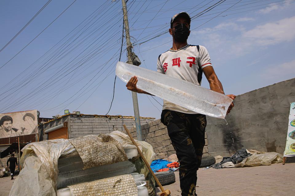 Yas Khudair, a street vendor sells blocks of ice in Basra, Iraq, Sunday, July. 26, 2020. As temperatures soar to record levels this summer, Iraq's power supply falls short of demand again, providing a spark for renewed anti-government protests. Amid a nationwide virus lockdown, homes are without electricity for hours in the blistering heat. (AP Photo/Nabil al-Jurani)