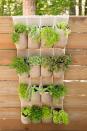 <p>Find an over-the-door shoe organizer that matches your aesthetic (linen works best!) and attach it to your fence for a space-saving herb garden. Stick a different kind of herb in each compartment, and add labels to help you keep track of what's what.</p>