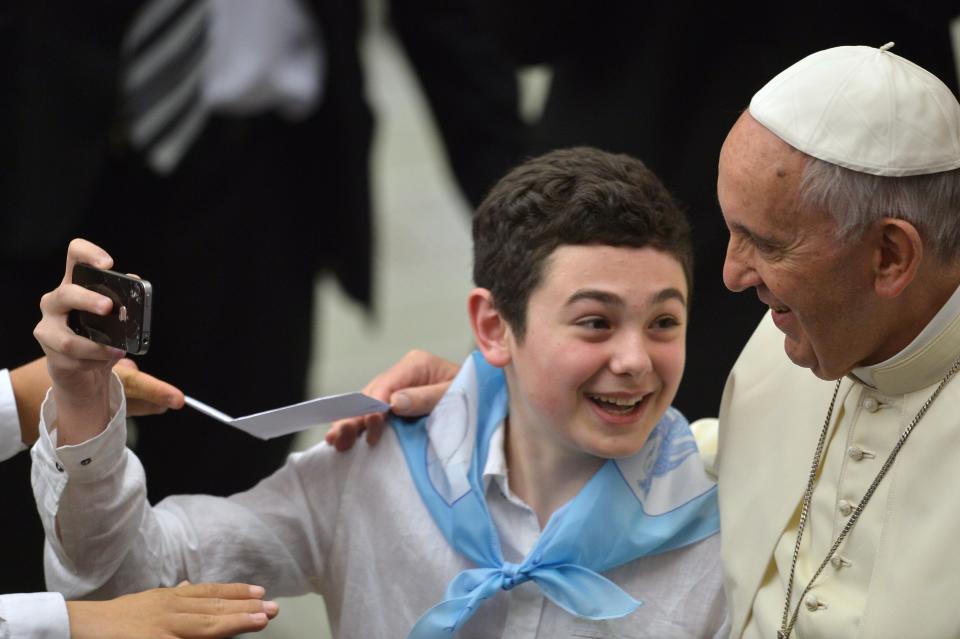 Pope Francis poses for a selfie with a young boy during an audience with the Societa Sportiva Lazio at Paul VI audience hall on May 7, 2015 at the Vatican.   AFP PHOTO / ALBERTO PIZZOLI        (Photo credit should read ALBERTO PIZZOLI/AFP/Getty Images)