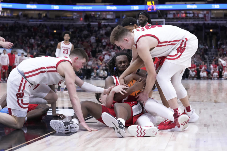 Ohio State's Bruce Thornton, center, protects the ball as Wisconsin's Connor Essegian, left, and Tyler Wahl force a jump ball during the second half of an NCAA college basketball game at the Big Ten men's tournament, Wednesday, March 8, 2023, in Chicago. Ohio State won 65-57. (AP Photo/Charles Rex Arbogast)