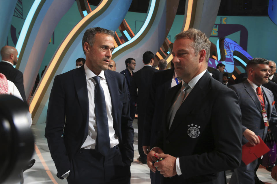 Germany's coach Hansi Flick, right, talks to Spain's head coach Luis Enrique after the 2022 soccer World Cup draw at the Doha Exhibition and Convention Center in Doha, Qatar, Saturday, April 2, 2022. (AP Photo/Hussein Sayed)