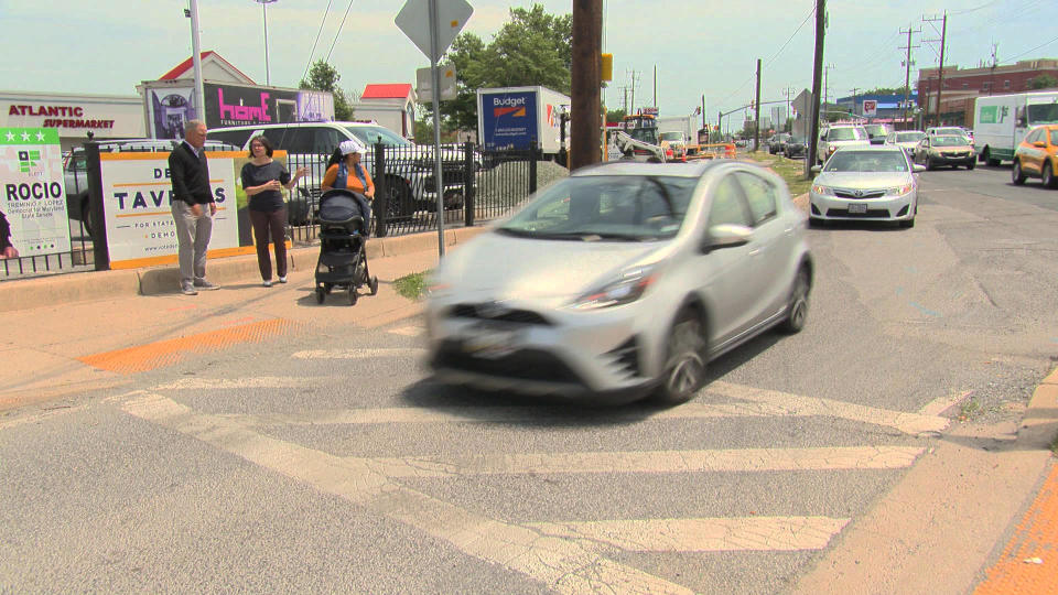 Correspondent Jim Axelrod with Beth Osborne at a crosswalk in Langley Park, Md., with no stoplight or call buttons for pedestrians to cross safely.  / Credit: CBS News