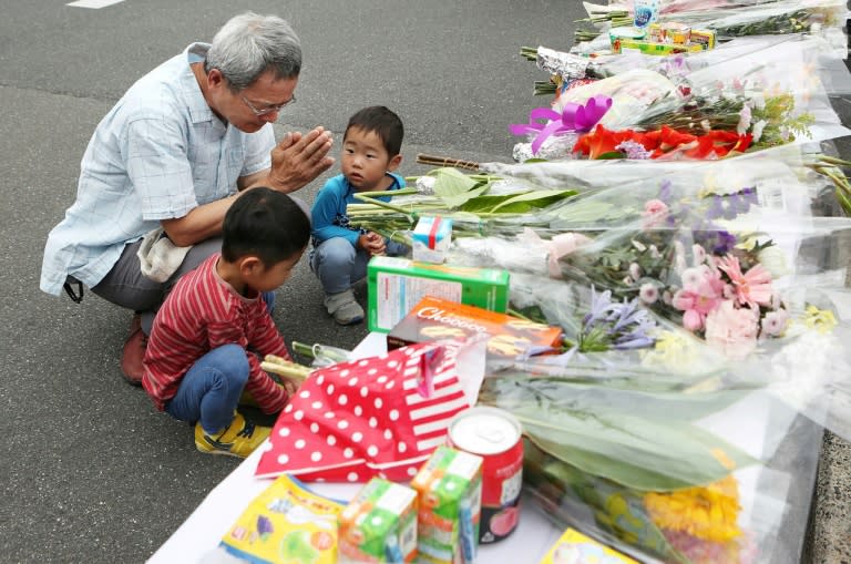 Residents pray at an altar for a nine-year-old student killed in Monday's earthquake in Osaka