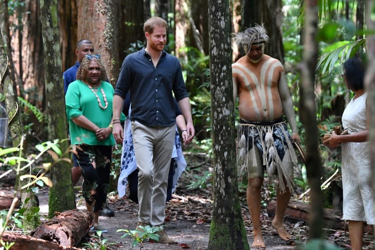 Prince Harry (C) walks with members of the Butchulla people, during the unveiling of the Queen's Commonwealth Canopy plaque at Pile Valley on Fraser Island