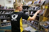 Sabine Standke, 32-year-old postwoman of the German postal and logistics group Deutsche Post, sorts mail at a sorting office in Berlin's Mitte district, December 4, 2013. Deutsche Post, the world's number one postal and logistics group, transported around 18 billion letters in 2012. REUTERS/Fabrizio Bensch (GERMANY - Tags: BUSINESS EMPLOYMENT)