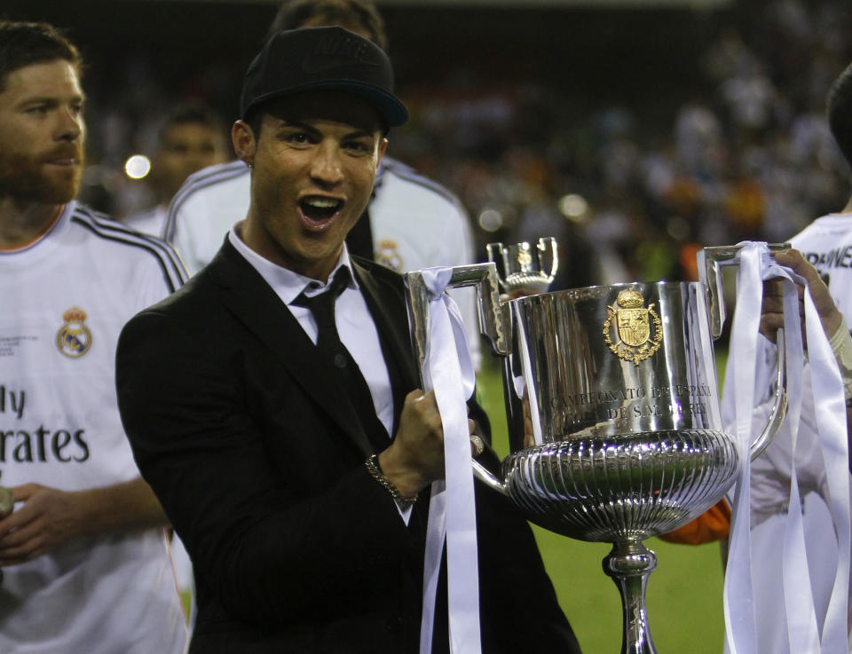 Real's Cristiano Ronaldo holds the trophy after Real Madrid won the final of the Copa del Rey between FC Barcelona and Real Madrid at the Mestalla stadium in Valencia, Spain, Wednesday, April 16, 2014. Ronaldo was injured and didn't play. (AP Photo/Alberto Saiz)