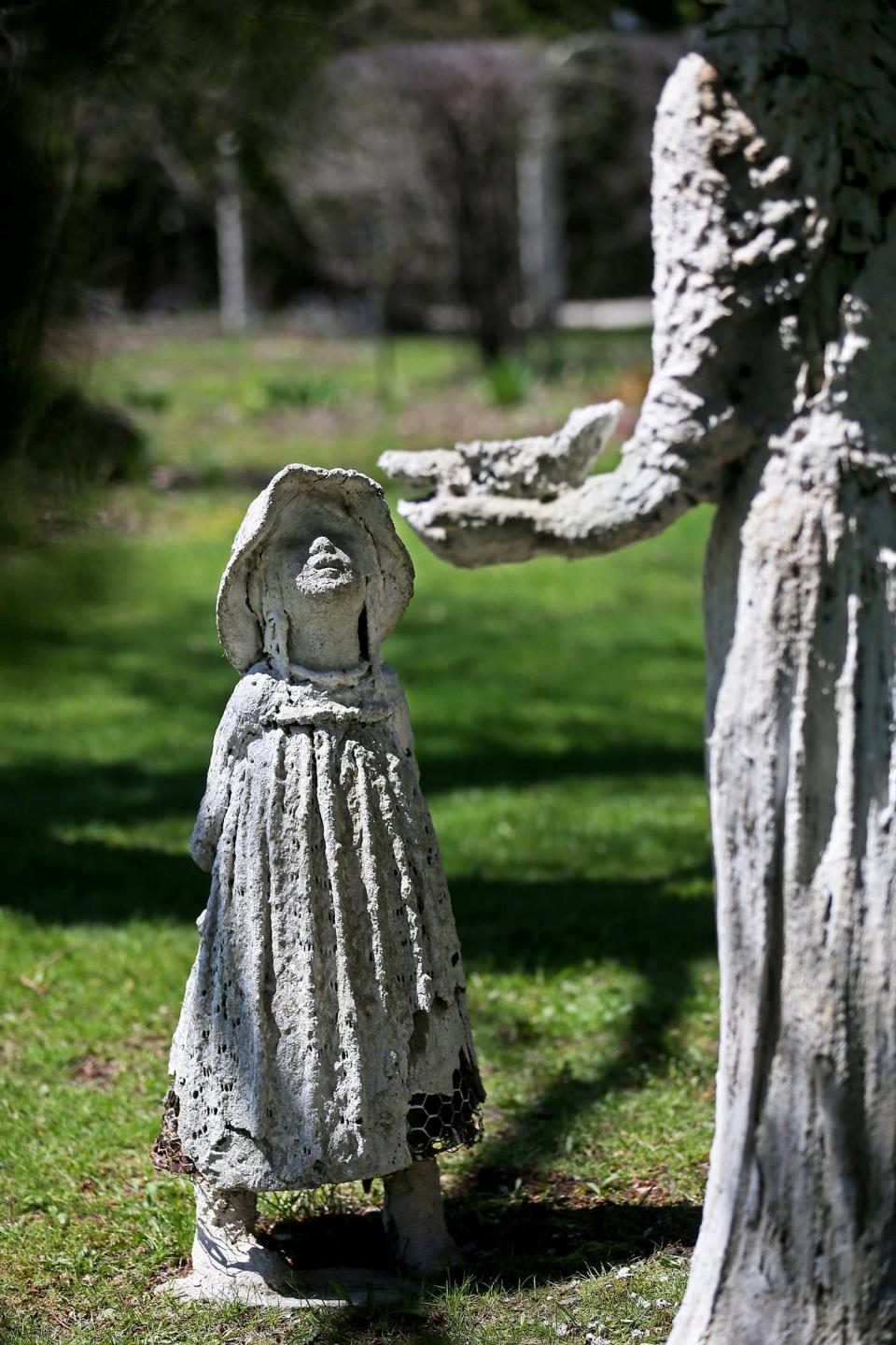 This statue group shows a woman holding a bird and a little girl hiding a doll behind her back. The artwork, by   Nancy Lindsey-Janusz, is at the home of Kathleen Stanislawski and Frank Paul.