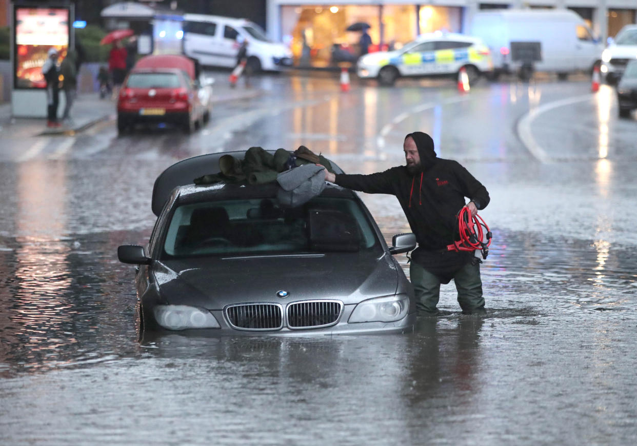 A man with car in a flooded street Sheffield, after torrential rain in the area  (PA)