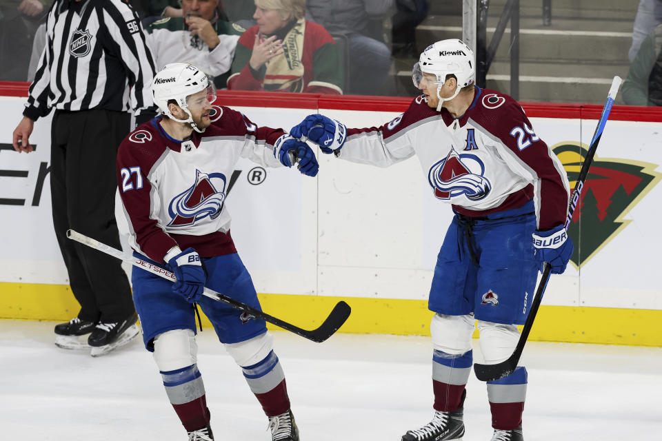 Colorado Avalanche center Nathan MacKinnon (29) and left wing Jonathan Drouin (27) celebrate MacKinnon's goal against the Minnesota Wild during the third period of an NHL hockey game Thursday, April 4, 2024, in St. Paul, Minn. Colorado won 5-2. (AP Photo/Stacy Bengs)