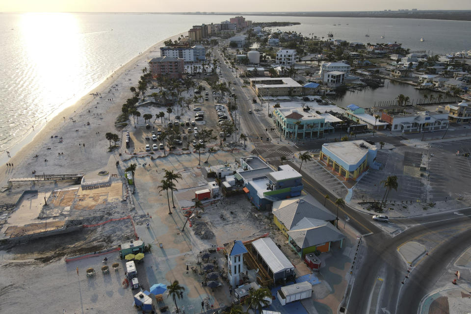 In this drone photo, restaurants operate from food trucks with outdoor seating in the Times Square area, where many businesses were completely destroyed during Hurricane Ian, in Fort Myers Beach, Fla., Wednesday, May 10, 2023. With this year's Atlantic hurricane season officially beginning June 1, recovery is far from complete in hard-hit Fort Myers Beach, Sanibel and Pine Island. Blank concrete slabs reveal where buildings, many of them once charming, decades-old structures that gave the towns their relaxed beach vibe, were washed away or torn down. (AP Photo/Rebecca Blackwell)