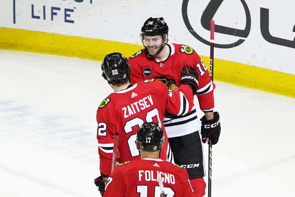 Chicago Blackhawks center Jason Dickinson (16) celebrates his goal against the St. Louis Blues with defenseman Nikita Zaitsev (22) during the second period of an NHL hockey game Saturday, Dec. 9, 2023, in Chicago. (AP Photo/David Banks)