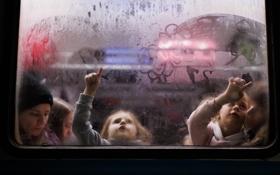 Two girls evacuated to the city of Lviv in Western Ukraine paint the foggy glass of on a train carriage window  - Europa Press News
