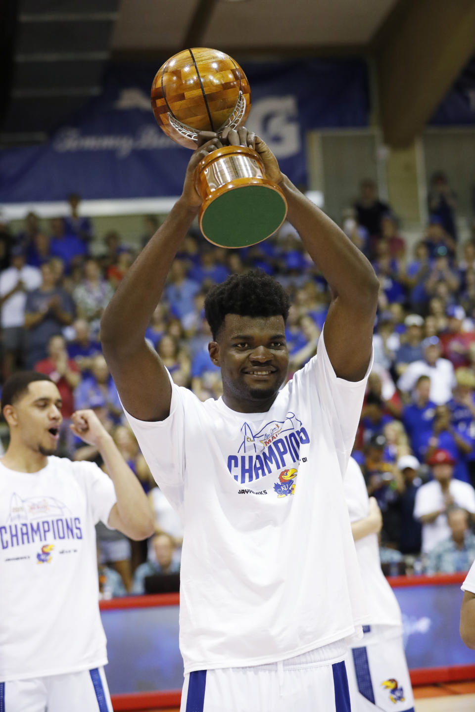 Kansas center Udoka Azubuike raises the MVP trophy after he and guard Devon Dotson shared the award, Wednesday, Nov. 27, 2019, in Lahaina, Hawaii. Kansas defeated Dayton in 90-84 in overtime. (AP Photo/Marco Garcia)