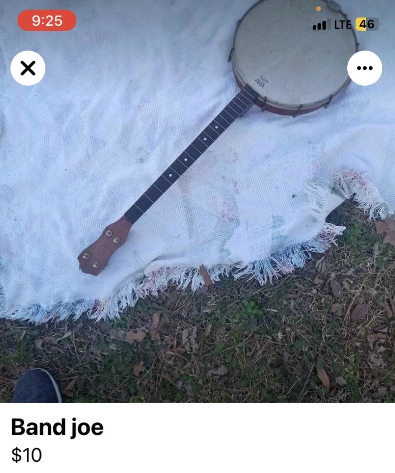 Banjo with damaged skin on a frayed blanket, grass background, screenshot of an online sale listing for $10