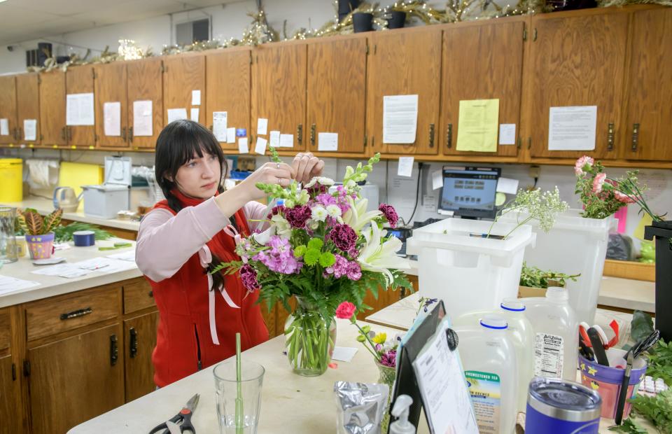 Becks Florist employee Kira Vaden works on an arrangement at her work station at the East Peoria shop.