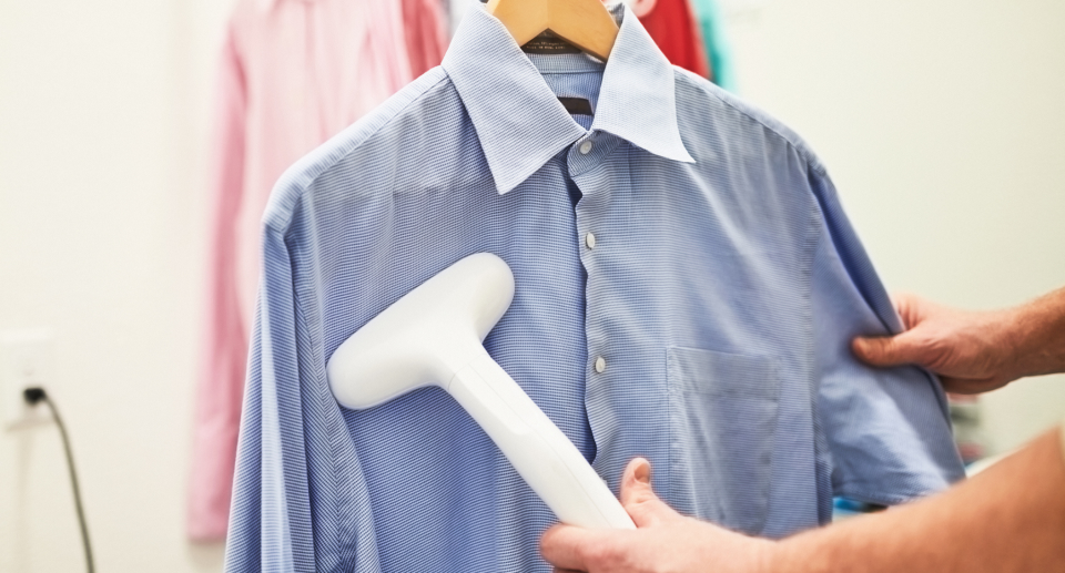 steamer, hand holding white steamer steaming blue men's shirt, Amazon shoppers call this handheld steamer 