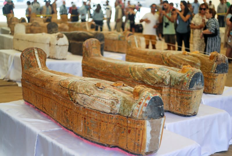 Tourists look at painted ancient coffins at Al-Asasif necropolis, unveiled by Egyptian antiquities officials in the Valley of the Kings in Luxor