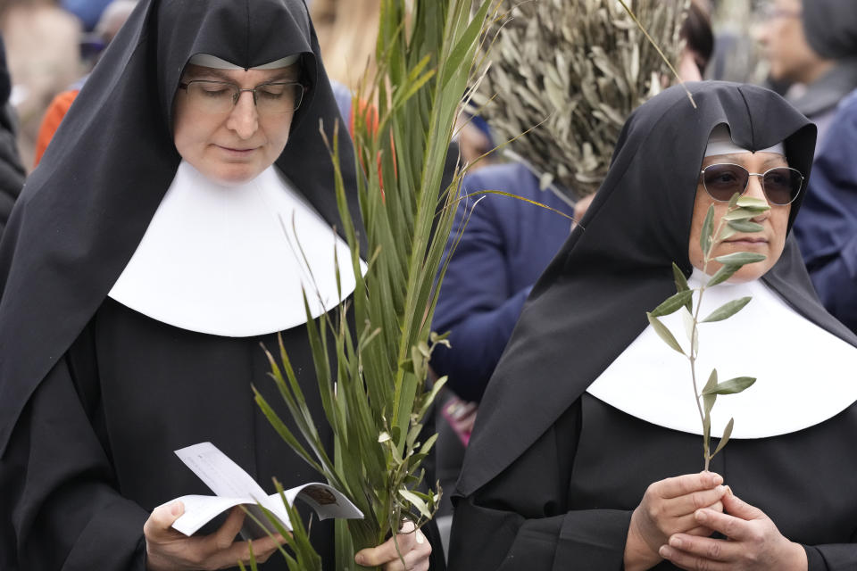 Nuns wait for the start of the Palm Sunday's mass celebrate by pope Francis in St. Peter's Square at The Vatican Sunday, April 2, 2023 a day after being discharged from the Agostino Gemelli University Hospital in Rome, where he has been treated for bronchitis, The Vatican said. The Roman Catholic Church enters Holy Week, retracing the story of the crucifixion of Jesus and his resurrection three days later on Easter Sunday. (AP Photo/Andrew Medichini)