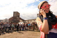 BERLIN, GERMANY - JULY 21: An attendee wearing pink glasses speaks on a mobile phone during the second annual Hipster Olympics on July 21, 2012 in Berlin, Germany. With events such as the "Horn-Rimmed Glasses Throw," "Skinny Jeans Tug-O-War," "Vinyl Record Spinning Contest" and "Cloth Tote Sack Race," the Hipster Olympics both mocks and celebrates the Hipster subculture, which some critics claim could never be accurately defined and others that it never existed in the first place. The imprecise nature of determining what makes one a member means that the symptomatic elements of adherants to the group vary in each country, but the archetype of the version in Berlin, one of the more popular locations for those following its lifestyle, along with London and Brooklyn, includes a penchant for canvas tote bags, the carbonated yerba mate drink Club Mate, analogue film cameras, asymmetrical haircuts, 80s neon fashion, and, allegedly, a heavy dose of irony. To some in Berlin, members of the hipster "movement" have replaced a former unwanted identity in gentrifying neighborhoods, the Yuppie, for targets of criticism, as landlords raise rents in the areas to which they relocate, particularly the up-and-coming neighborhood of Neukoelln. (Photo by Adam Berry/Getty Images)