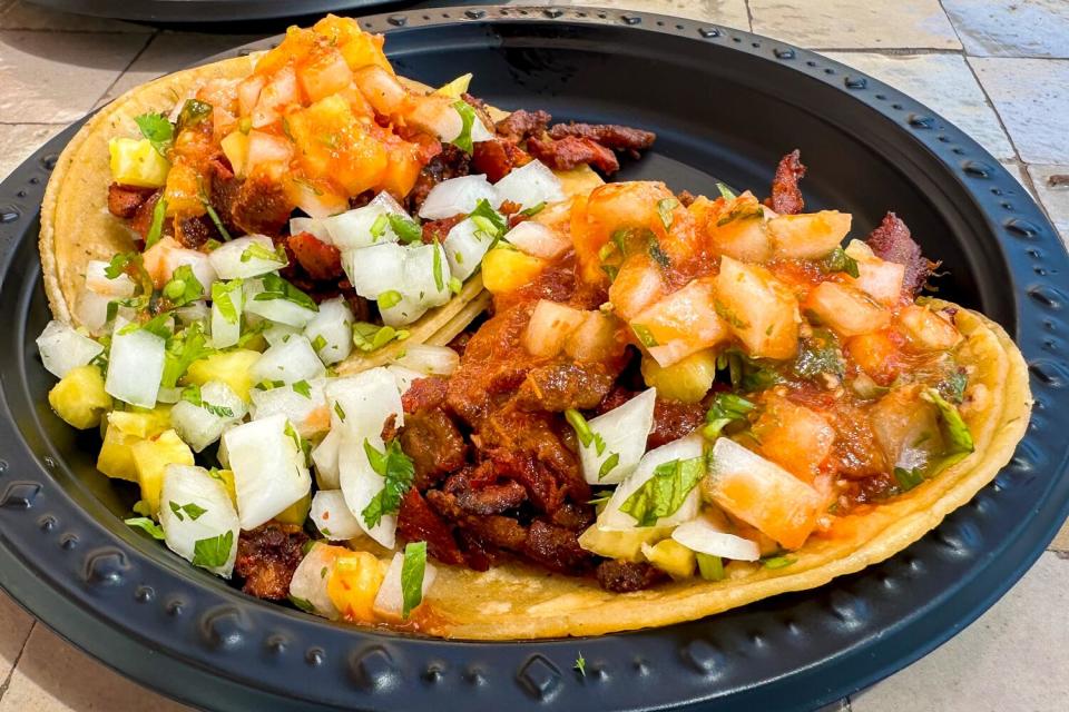 Al pastor tacos from Tacos Los Guichos inside Mercado González