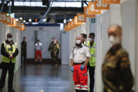 FILE - In this file photo dated Sunday, Dec. 27, 2020, staff waiting for the start of the vaccination against the COVID-19 disease at the Arena Treptow vaccine center in Berlin, Germany. Slow off the blocks in the race to immunize its citizens against COVID-19, Germany faces the problem of having a glut of vaccines and not enough arms to inject. With its national vaccine campaign lagging far behind that of Israel, Britain and the United States, there are growing calls in this country of 83 million to ditch or rewrite the rulebook.(AP Photo/Markus Schreiber, FILE)