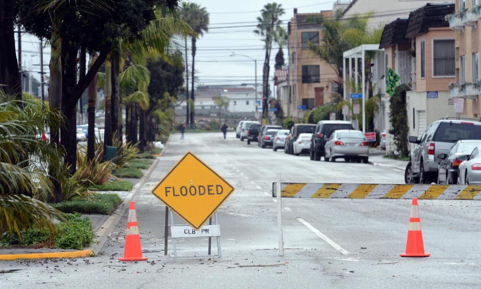 A barricade still stands up along Ocean Boulevard between 66th and 72nd Place, along the Peninsula in Long Beach, Calif., Sunday, March 2, 2014. Flooding occurred when heavy surf eroded the protective sand berm Saturday night, resulting in 20 homes on Ocean Blvd between 66th and 72nd Place, sustaining damage to either living levels or parking areas. No residents were reported to be displaced, said Long Beach Fire Department Public information Officer Will Nash. (AP Photo/Daily Breeze, Stephen Carr)