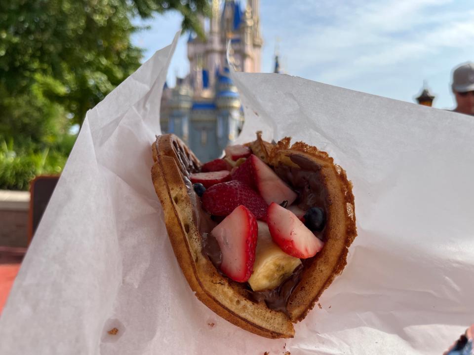 hand holding up a fresh fruit waffle sandwich from sleepy hollow in magic kingdom