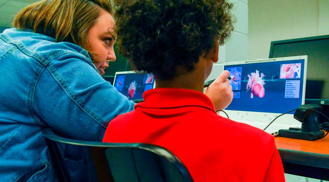 Third-grade teacher Amanda Dudas helps a student on Monday, Aug. 15, 2022, bring a 3-dimensional heart back to their screen while using a pencil-sized stylus on the first day of school at Mossy Oaks Elementary School.