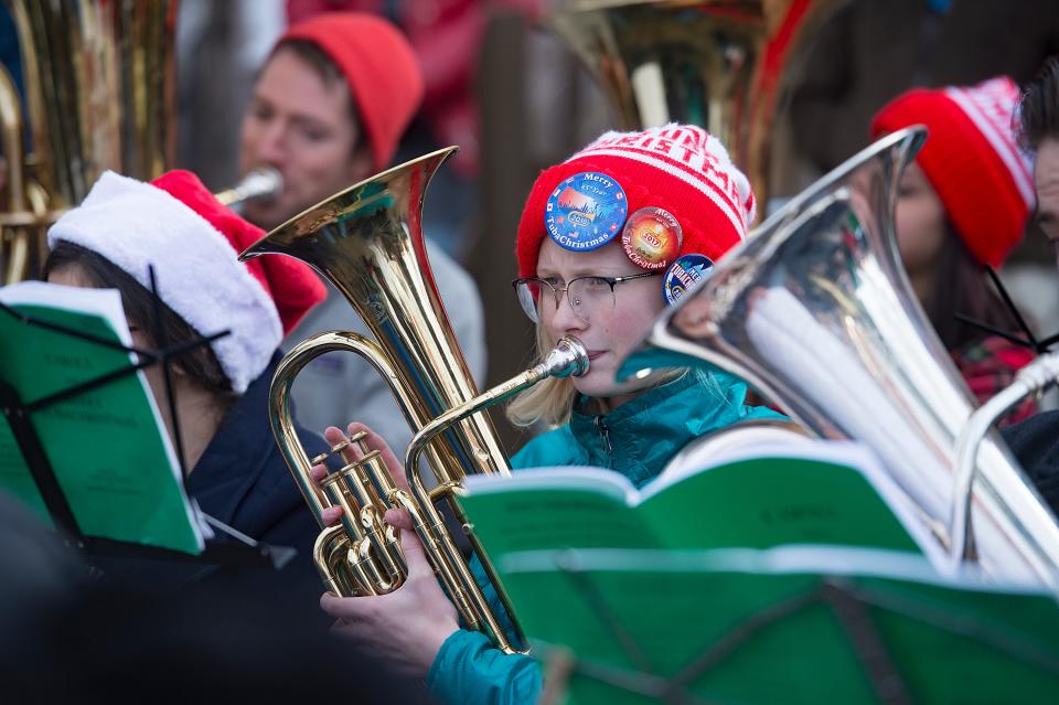 Tubas and euphonium players read music during a Tuba Christmas performance in Oak Street Plaza on in 2018.