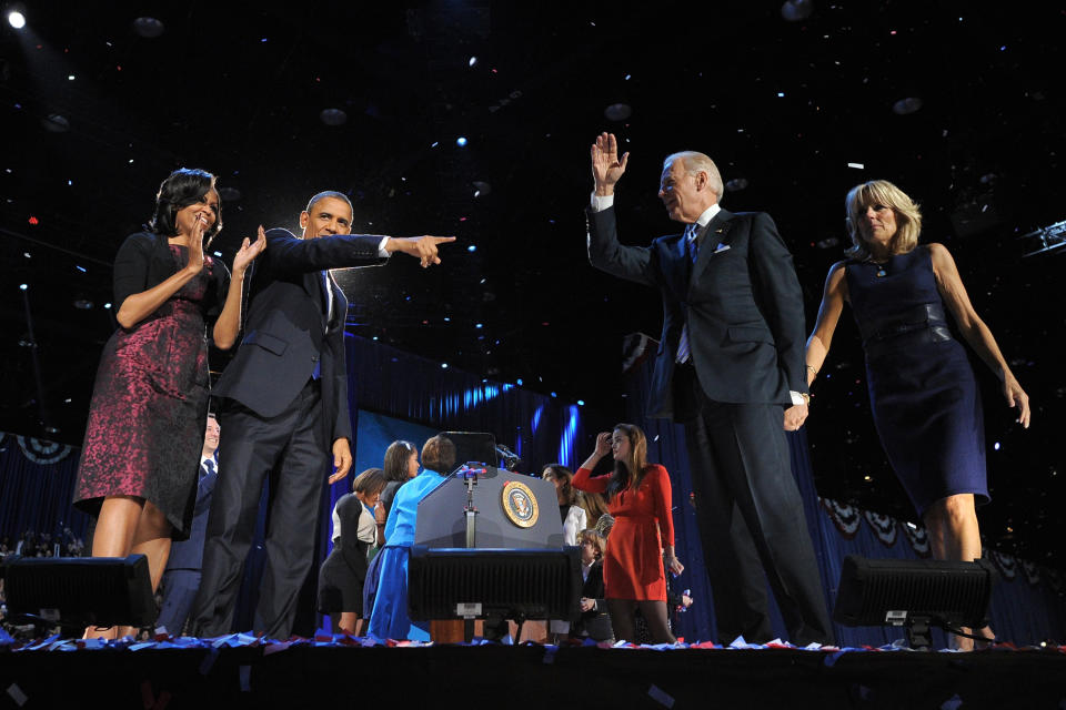 US President Barack Obama, flanked by First Lady Michelle Obama, points to his partner Vice-President Joe Biden, followed by Second Lady Jill Biden following his victory speech on election night November 6, 2012 in Chicago, Illinois. President Barack Obama swept to re-election Tuesday, forging history again by transcending a slow economic recovery and the high unemployment which haunted his first term to beat Republican Mitt Romney. AFP PHOTO/Jewel Samad        (Photo credit should read JEWEL SAMAD/AFP/Getty Images)