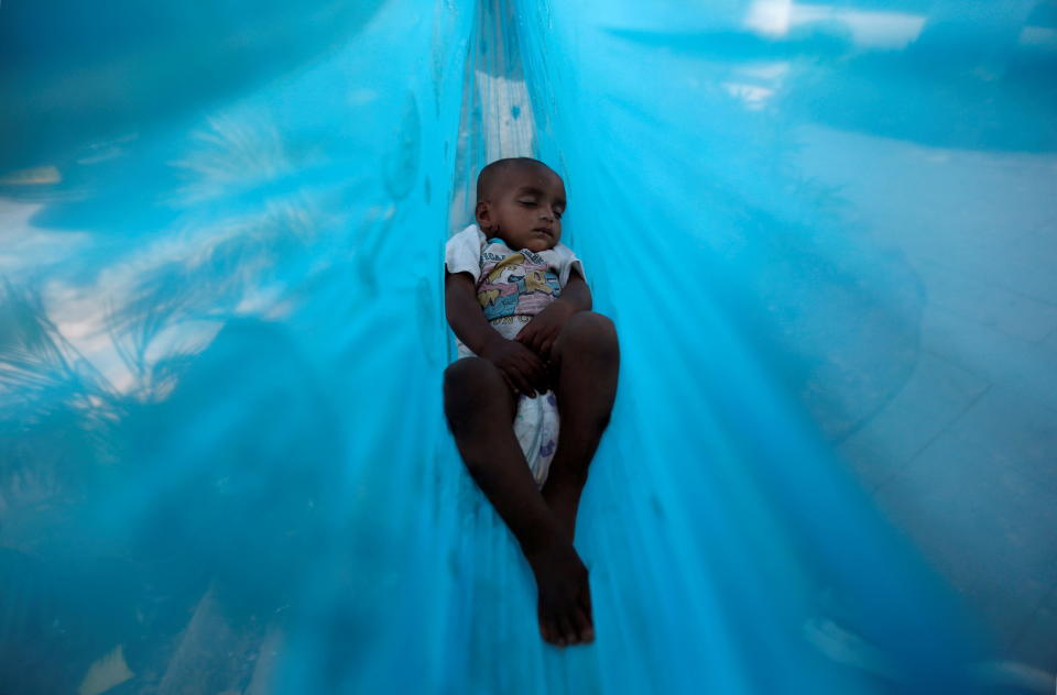 Eleven-month-old Sakeena sleeps in a hammock on the promenade next to a lake in Mumbai, India, March 21, 2017. / Credit: DANISH SIDDIQUI/REUTERS
