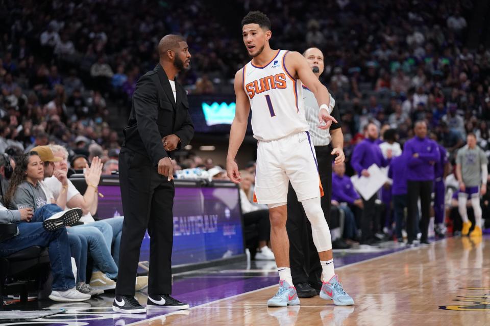 Mar 20, 2022; Sacramento, California, USA; Phoenix Suns guard Devin Booker (1) talks with guard Chris Paul before a play against the Sacramento Kings in the fourth quarter at the Golden 1 Center.