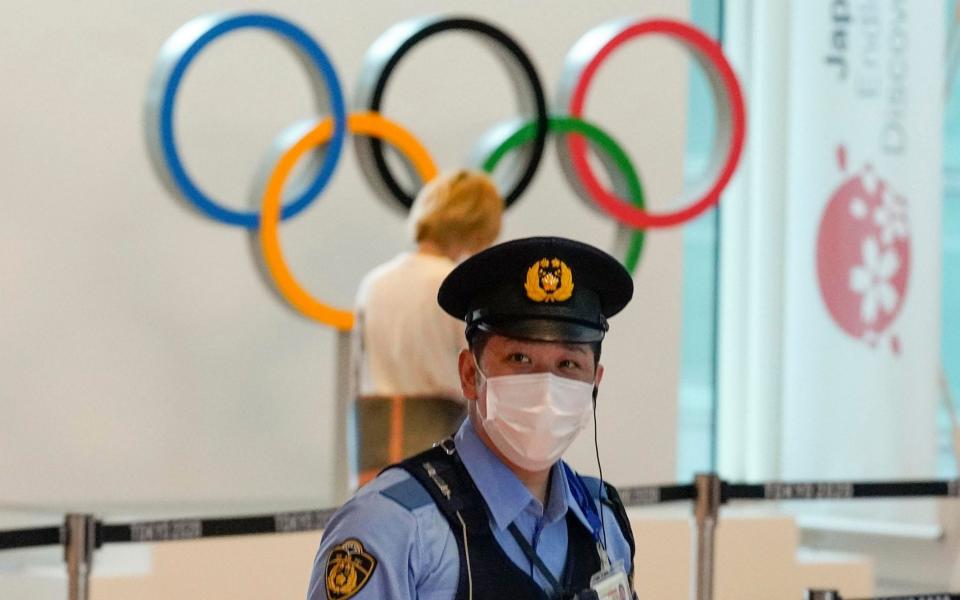 A Japanese policeman stands on guard at an arrival exit of Tokyo International Airport at Haneda, Japan - KIMIMASA MAYAMA/EPA-EFE/Shutterstock