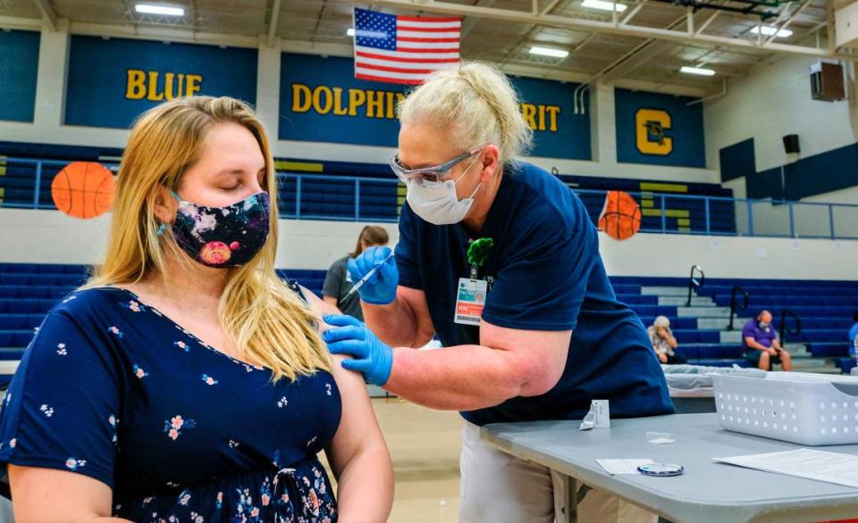 Caitlyn Creamer, an upper elementary assistant guide at Lowcountry Montessori School, closes her eyes on Thursday, March 11, 2021 as Dee Ann Sanders, an emergency room RN administers Creamer’s first shot of the Pfizer-BioNTech COVID-19 vaccine in the gymnasium at Battery Creek High School earlier this year. The city of Beaufort is asking for input from residents on how best to spend $6.54 million in American Rescue Plan money.