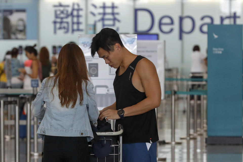 Travellers prepare near the departure gates at the airport in Hong Kong, Wednesday, Aug. 14, 2019. Flight operations resumed at the airport Wednesday morning after two days of disruptions marked by outbursts of violence highlighting the hardening positions of pro-democracy protesters and the authorities in the Chinese city that's a major international travel hub. (AP Photo/Vincent Thian)