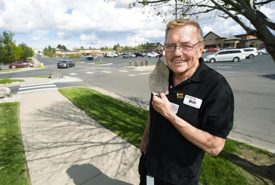 In this Wednesday, May 19, 2021, photograph, Bill Easton, a checker at a Safeway grocery store, is shown in the shopping center in which the store is located in Aurora, Colo. Easton, like many other workers in retail sales jobs, is fully vaccinated but is concerned about risks posed as retailers change their mask-wearing policies for customers. (AP Photo/David Zalubowski)