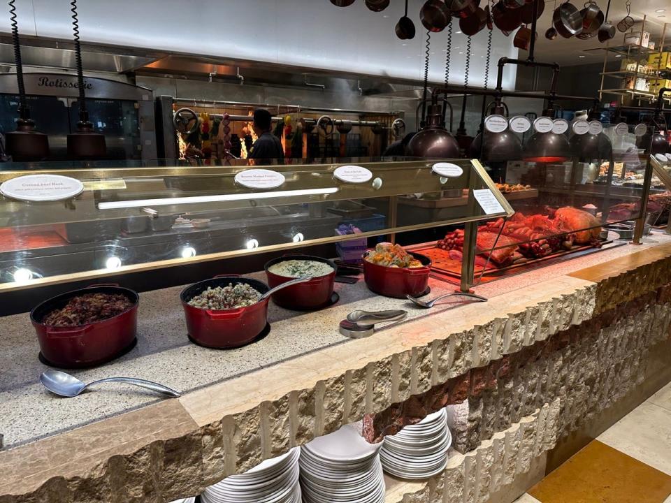 Pots of meat at Bacchanal buffet next to display of sausages and meats