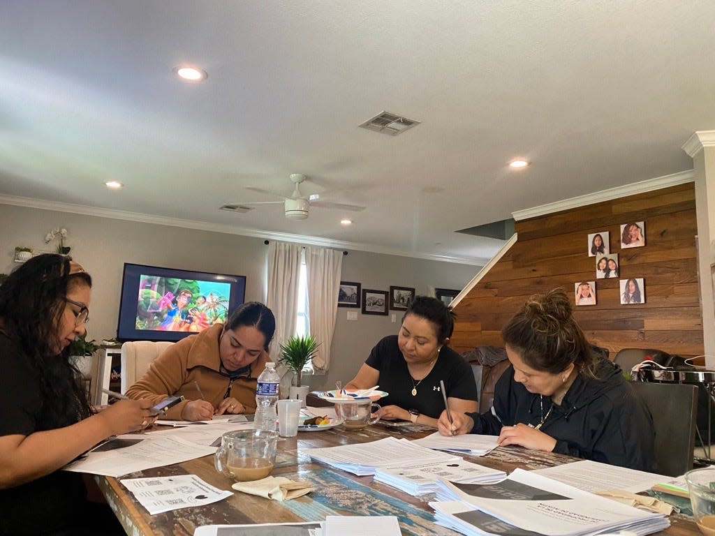 From left, Del Valle residents Karina Avalos, Lupita Salazar, Lulú Martínez and Claudia Servín fill out interest forms for a food co-operative at a house meeting on Thursday, March 21, 2024.