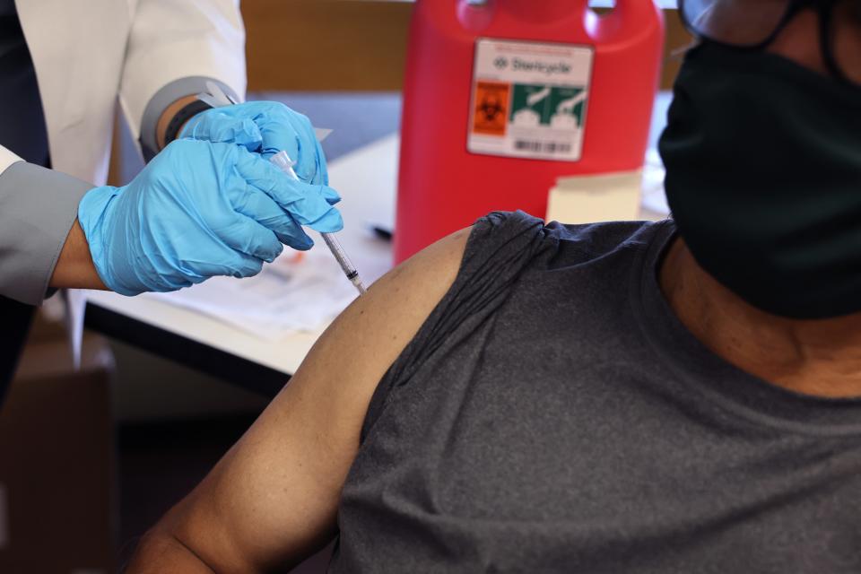 A pharmacist gives a COVID-19 vaccine booster shot in September 2022.