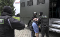 In this photo taken from video released by Belarusian KGB, State TV and Radio Company of Belarus on Wednesday, July 29, 2020, Belarusian KGB officers detain a Russian man in a sanitarium outside in Minsk, Belarus. Belarusian officials said that more than 30 detained employees of private Russian military contractor Wagner are facing a criminal probe on charges of plotting terror attacks in Belarus amid a presidential election campaign. (Belarusian KGB, State TV and Radio Company of Belarus via AP)