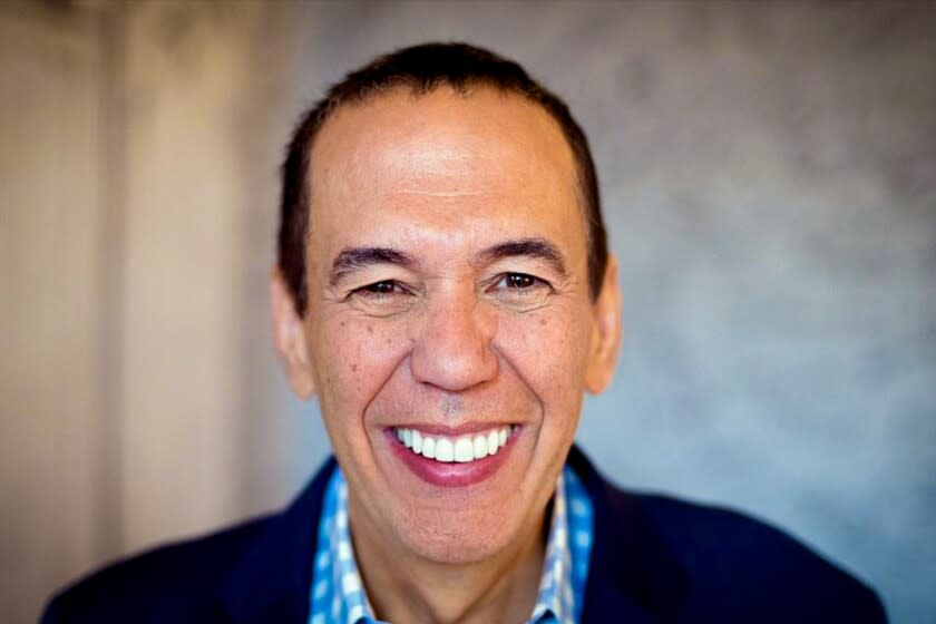 A close-up photo of a freckled man's face. He is smiling with short brown hair