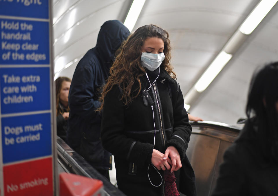 A woman at Green Park station on the London Underground tube network wearing a protective facemask.